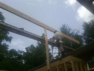 Carpenter setting a ridge beam over a new addition frame — Ice Dam Removal by Roofing Brothers in South Carver