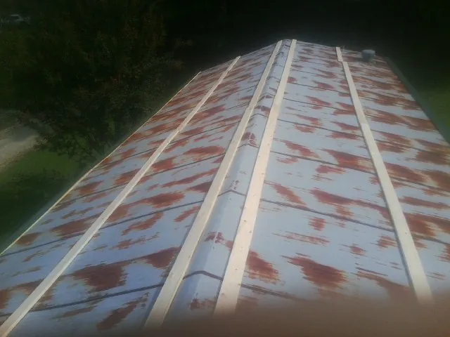 Rusted metal roof panels with new wood purlins before replacement — Storm Damage Roof Repair in South Carver by Roofing Brothers